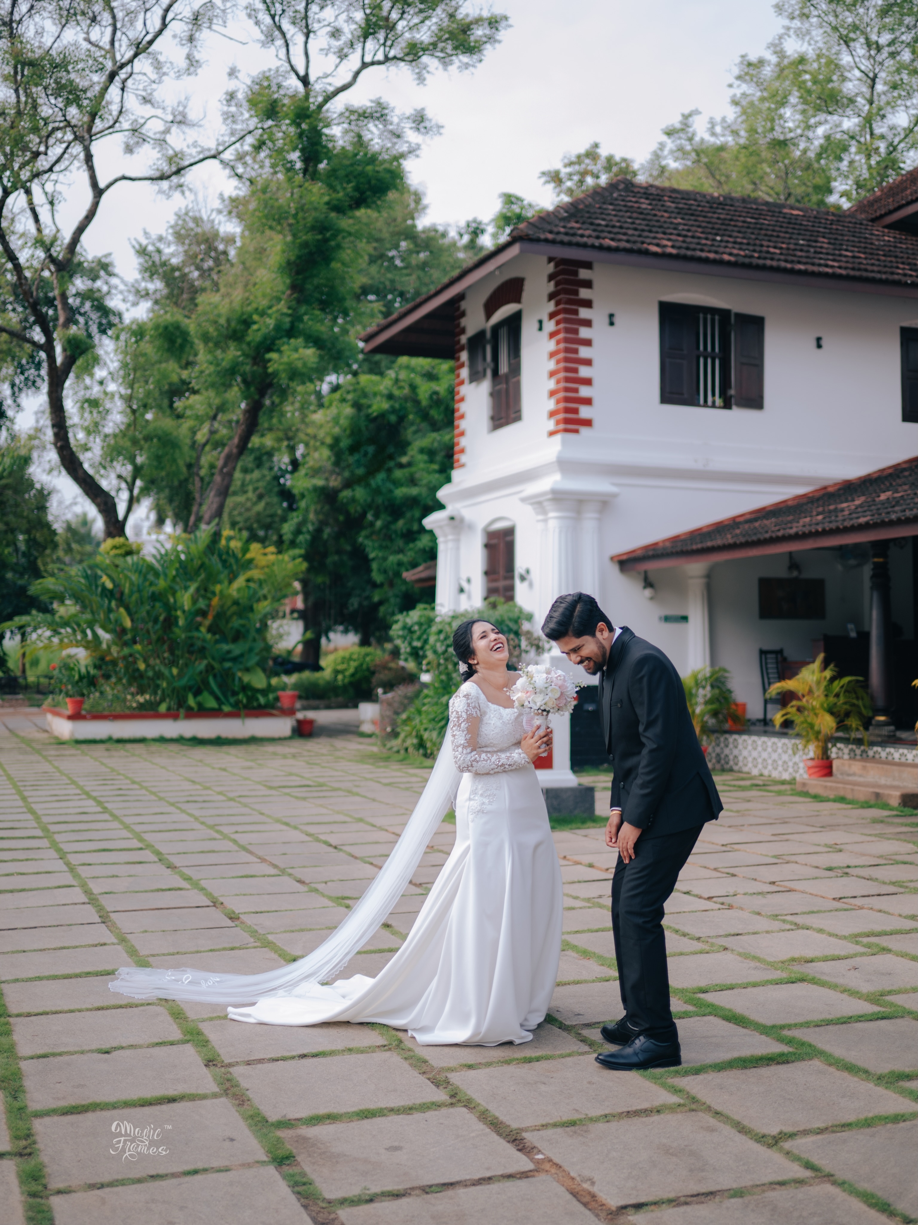 Wedding couple laughing in a courtyard